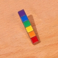 Metalowa przypinka LGBT kolorowa tęczowa na drewnianym blacie