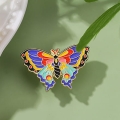 przypinka emaliowana motyl kolorowy na zielonym tle