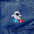 przypinka astronauta deskorolka pin na jeansie denim