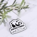 przypinka panda mood z pandą i przełącznikiem na tle z rośliną
