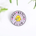 przypinka Bad Bitch Club na białym tle z zielonymi liśćmi