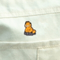przypinka garfield na beżowej kurtce