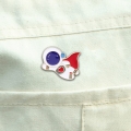 przypinka astronauta na koszuli biała tkanina