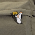 Metalowa przypinka Droopy Happy na kieszeni spodni khaki