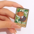 Przypinka kapibara capy-italism trzymana w dłoni - skala rozmiaru