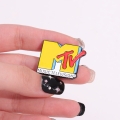 przypinka MTV w dłoni rozmiar metal