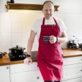 fartuch kuchenny czerwony Polska - mężczyzna w kuchni z kubkiem