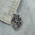 Pins czarne serce metalowe przypięte do jeansowej kurtki