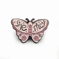 metalowa przypinka różowy motyl she/they zaimki